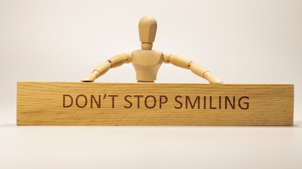 Don't stop smiling. The word itself says 'I'm possible written on wooden surface. Business and...