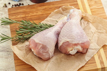 Raw chicken leg over board