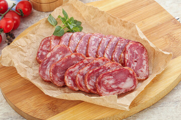 Sliced salami sausages over board