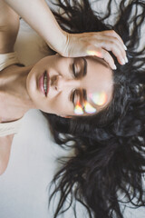Closeup portrait of smiling woman with ray of rainbow light on her face. Rainbow optical flare from...
