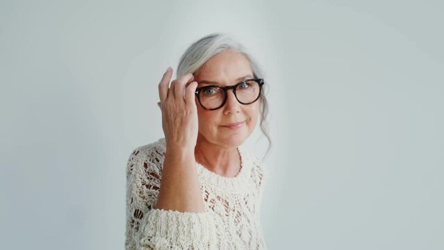 Elderly woman in casual clothes posing on a white background