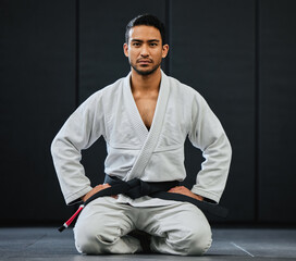 . Male coach ready for karate training at fitness studio, looking serious at dojo practice in gym...