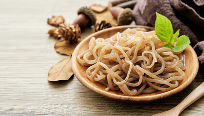 concept of salad brown konjac noodle and green leaves in wooden plate on white table background    ...
