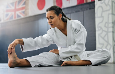 Exercise, fight and workout stretch of a karate school student with focus before training start....