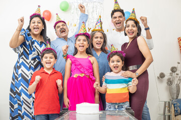 Cheerful indian asian generational family celebrate indoor birthday party. - Powered by Adobe