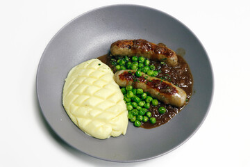 bangers and mash, grilled pork sausage with mash potato, brown onion gravy and steamed green peas