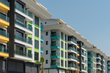 Modern freshly built apartment buildings on a sunny day with blue sky.