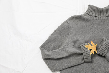 Gray sweater with autumn leaf, space for text
