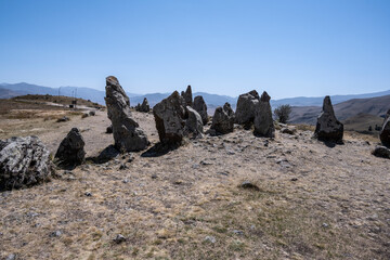 ancient stone observatory against the background of yellow hills in the mountains of Armenia