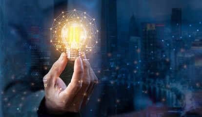hand of business man holding light bulb and digital data network connection, Idea, and innovation concept