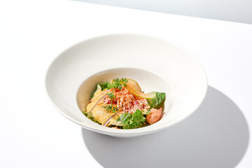 Elegant salad with crab meat, espuma sauce and lettuce on white table with harsh shadows. Green salad with crab and creamy sauce in summer menu. Aesthetic food. Seafood appetizer.