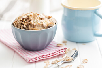Whole grain cereal flakes. Wholegrain breakfast cereals in bowl on kitchen table.
