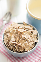 Whole grain cereal flakes. Wholegrain breakfast cereals in bowl on kitchen table.