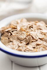 Whole grain cereal flakes. Wholegrain breakfast cereals in bowl on kitchen table.