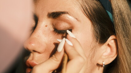Make-up artist applies makeup with a brush on the eyelid