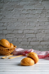 buns in a wicker basket on a white wooden background, with copy space, delicious homemade buns,...