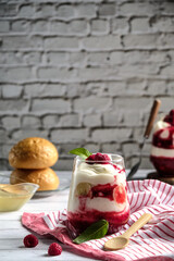 raspberry dessert, milk dessert with raspberries bananas and honey, on a light background, sweet breakfast for a vegetarian 