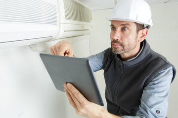 man carefully checking a new installed ac