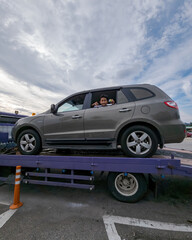 Fototapeta na wymiar Perak, Malaysia - Aug 7, 2022 : Broken car on the truck with passenger to the workshop.