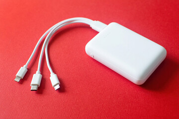 Powerbank on red background. Powerbank with different connectors.