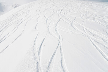 top view of the snow-covered slope of the mountain, traces from skiers and snowboarders, no people - obrazy, fototapety, plakaty
