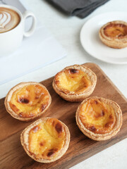 Portuguese eggtart or Egg tart, traditional Portuguese dessert. Served on a white plate. Blurred background and selective focus image.
