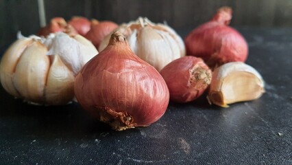 Bunch of onions and garlic on a black background