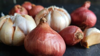 Bunch of onions and garlic on a black background