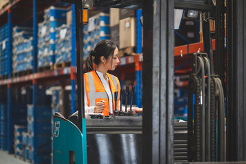 Smart engineer woman worker doing stocktaking of product management in forklift machine on shelves...