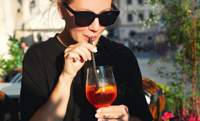 Beautiful girl drinking a cocktail in a cafe