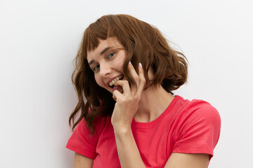 a close portrait of a happy, beautiful, attractive red-haired woman playfully hiding her face...