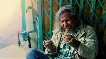 An elderly Asian man is homeless is very desperate as his last pair of glasses is broken and his...