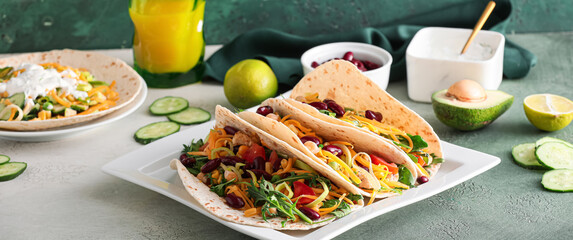 Plate with tasty tacos on table