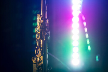 A photo of a saxophone in front of light soffits that can serve as a background or abstraction