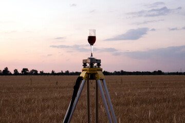 A glass of wine instead of a geodetic instrument as a symbol of the beginning of geodetic work in an open field