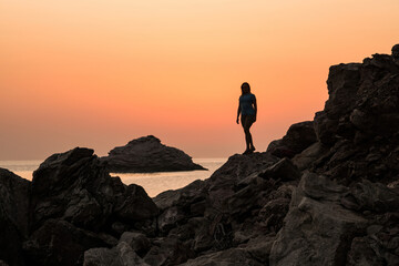 Silhouette of a girl on a background of stone and sea