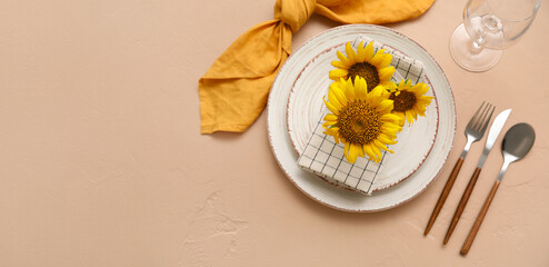 Beautiful table setting with fresh sunflowers on color background with space for text