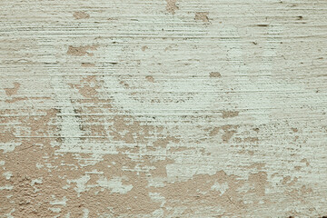 Beige paint brushed wall background with detailed texture. A concrete plastered surface with cracks and brush strokes.