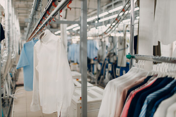 Dry cleaning clothes. Clean cloth chemical process. Laundry industrial dry-cleaning hanging clothes on rack - 524418405