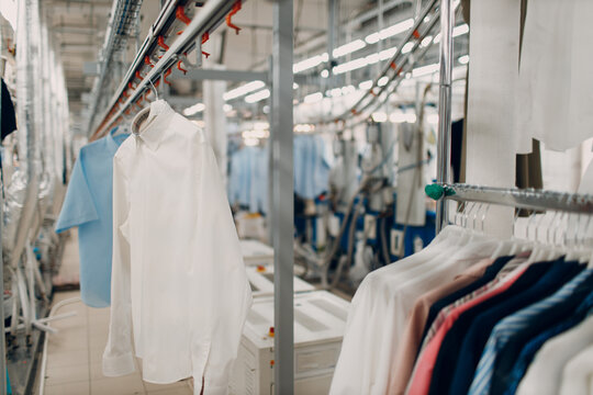 Dry cleaning clothes. Clean cloth chemical process. Laundry industrial dry-cleaning hanging clothes on rack