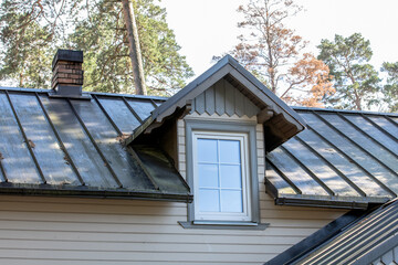 Fototapeta na wymiar Attic floor. Skylight in attic and brown metal roof