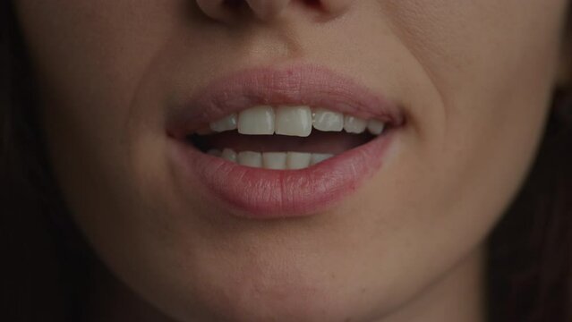 Close up of a caucasian woman lips doing a kiss and a smile in slow motion