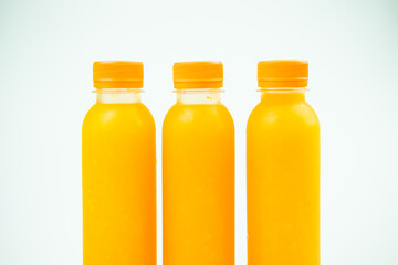 Three small bottles with orange juice. Close up