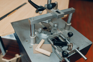 Framing Workshop. Machine cartridge for assembling corners brackets baguette handmade picture frame at studio.