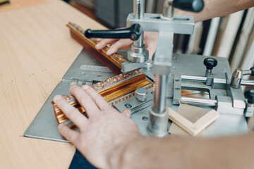 Framing Workshop. Assembling staples corners brackets baguette handmade picture frame at studio.