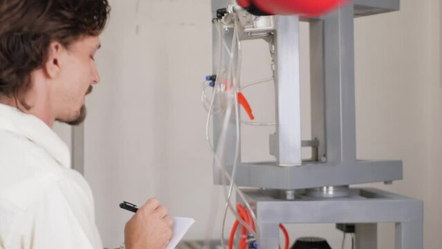 man records performance of boxer's robot. inventor monitors his device, pneumatic motor.