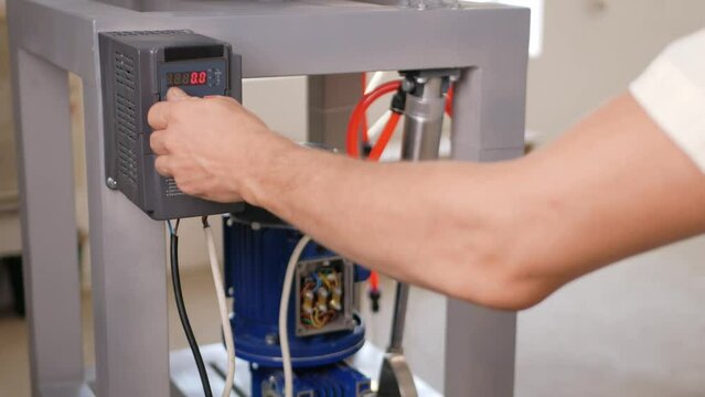 man turns on pneumatic motor, which is powered by air and compressor.