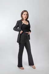 Full length body portrait of a young beautiful asian female businesswoman wearing full black business attire and pose with different gestures & emotions. Suitable for business presentation or slides.