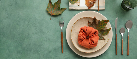 Beautiful autumn table setting on green background with space for text