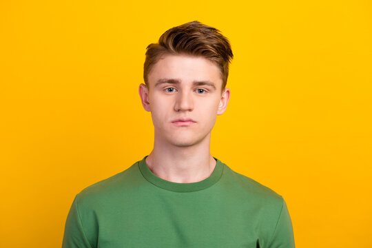 Young man wearing shirt standing over isolated yellow background with serious expression on face natural looking at camera